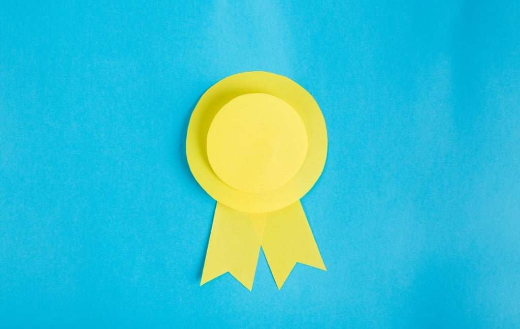 Yellow paper made ribbon on light blue background