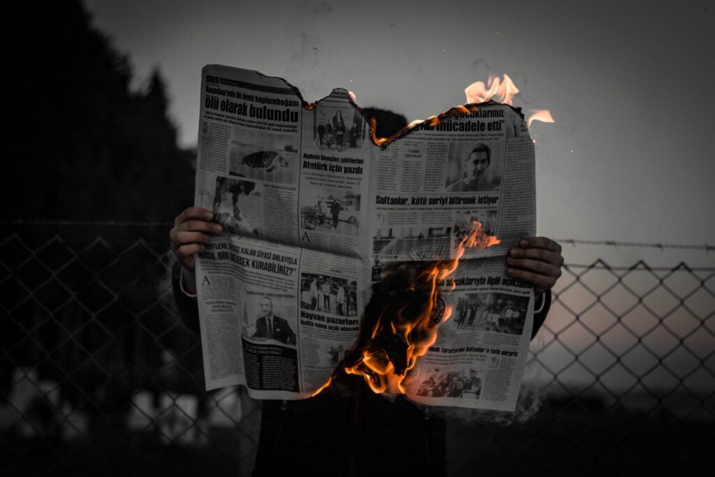 A Person Holding a Burning Newspaper