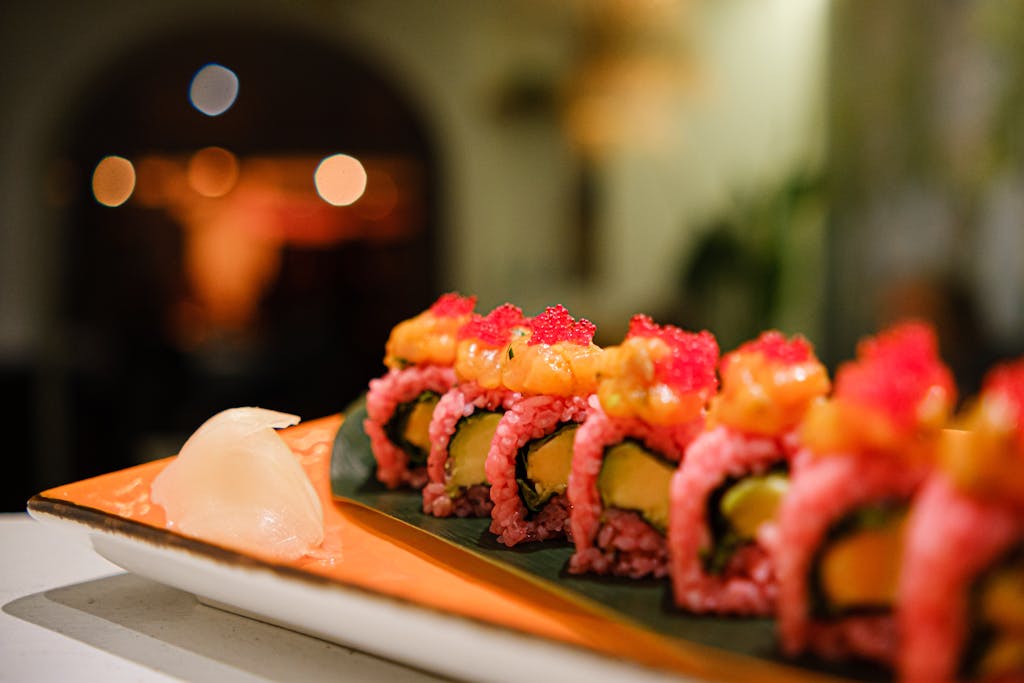Close-up of colorful Japanese sushi rolls with vibrant toppings on a plate.